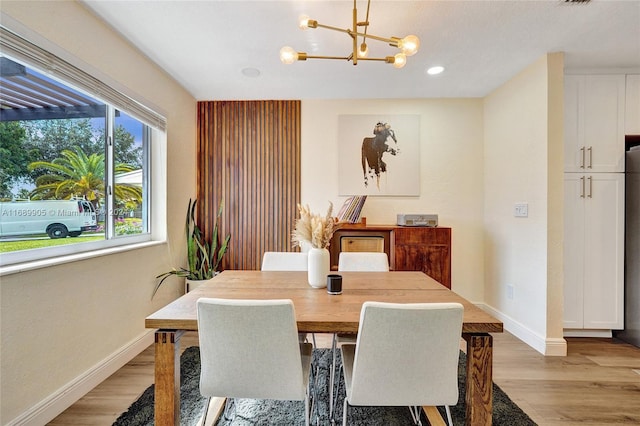 dining space featuring an inviting chandelier and light hardwood / wood-style flooring