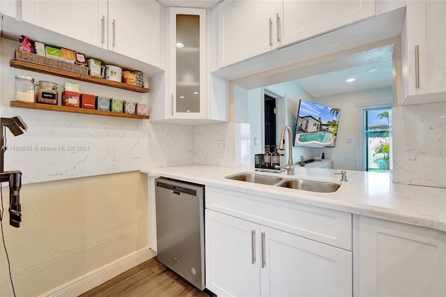 kitchen featuring stainless steel dishwasher, white cabinets, wood-type flooring, and sink