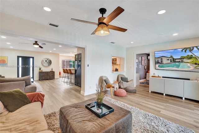 living room with ceiling fan and light wood-type flooring