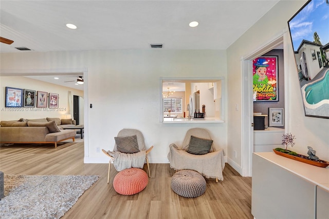 sitting room with ceiling fan and light hardwood / wood-style floors