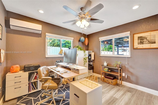 home office with light wood-type flooring, a wall unit AC, and ceiling fan