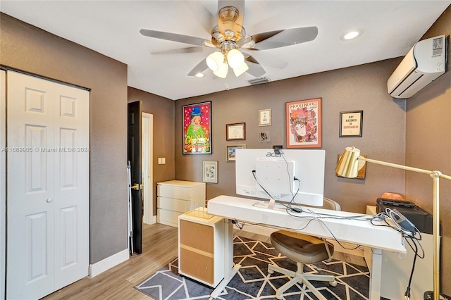 office space with a wall unit AC, ceiling fan, and hardwood / wood-style floors