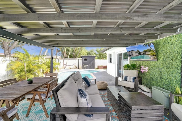 view of patio / terrace featuring outdoor lounge area, a fenced in pool, and a storage unit