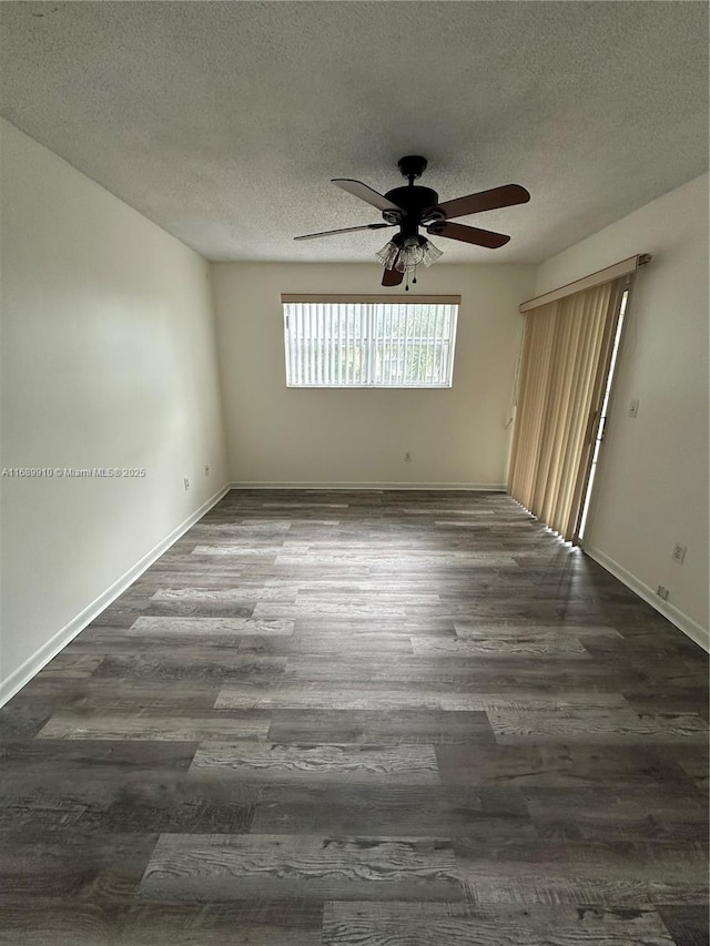 empty room featuring dark hardwood / wood-style flooring, ceiling fan, and a textured ceiling