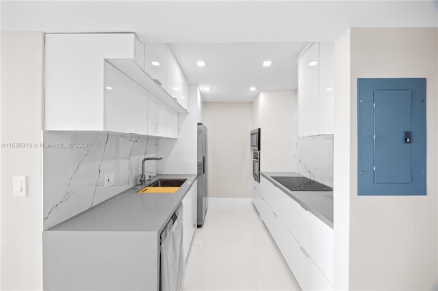 kitchen featuring electric panel, white cabinets, sink, tasteful backsplash, and stainless steel appliances