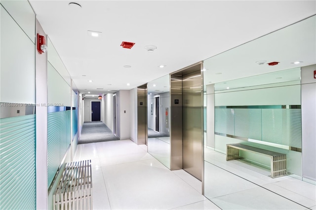 hallway featuring light tile patterned floors and elevator