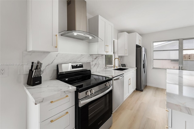 kitchen featuring white cabinets, appliances with stainless steel finishes, sink, and wall chimney range hood