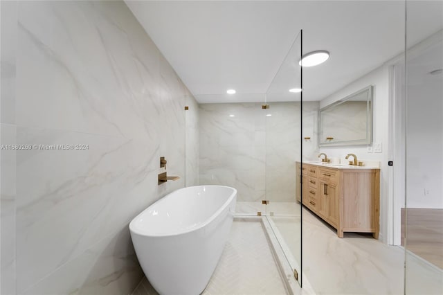 bathroom featuring tile walls, vanity, and plus walk in shower