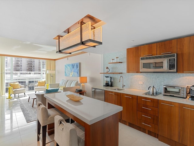 kitchen featuring brown cabinets, stainless steel appliances, and a sink