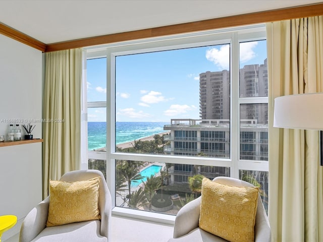 interior space with a beach view, a water view, and crown molding