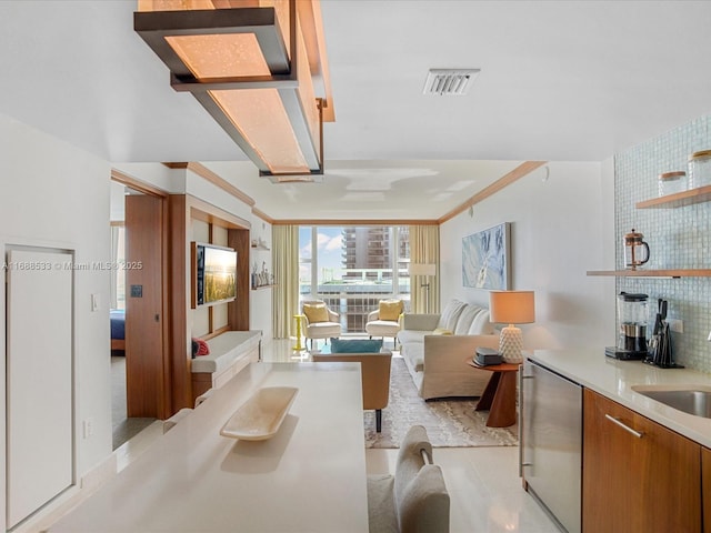 living area featuring visible vents and ornamental molding