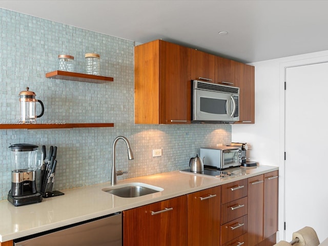kitchen with open shelves, a sink, brown cabinetry, stainless steel appliances, and backsplash