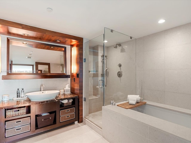 full bath with tile patterned flooring, backsplash, vanity, tile walls, and a stall shower
