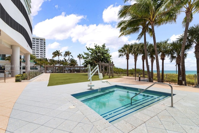 view of swimming pool with a community hot tub and a lawn