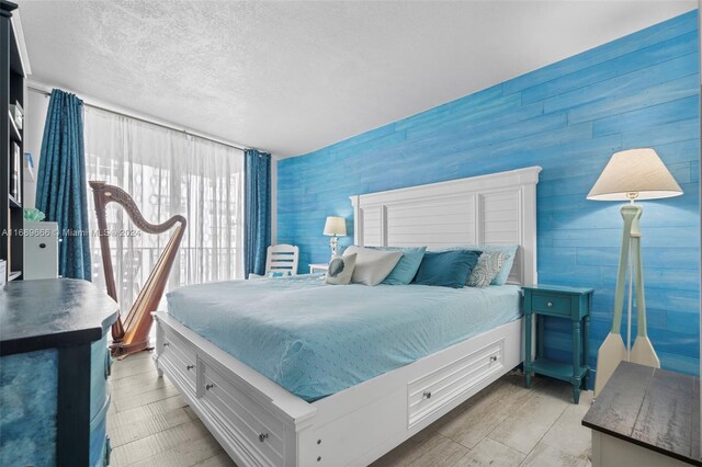 bedroom with light hardwood / wood-style flooring and a textured ceiling