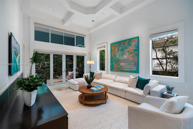 living room with coffered ceiling, a towering ceiling, beam ceiling, and plenty of natural light