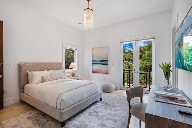 bedroom featuring a chandelier, multiple windows, french doors, and access to outside