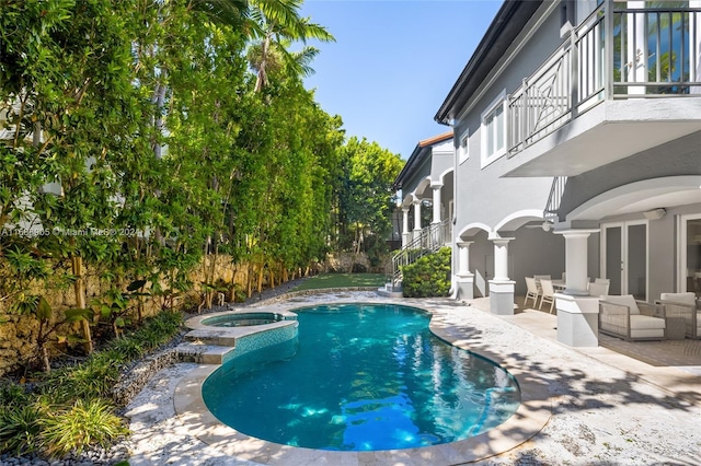 view of pool with outdoor lounge area, an in ground hot tub, and a patio area