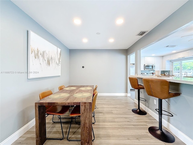 dining space with sink and light hardwood / wood-style floors