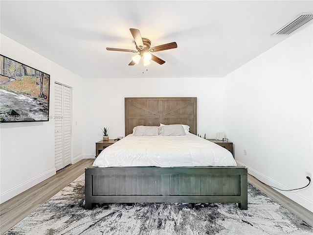 bedroom featuring hardwood / wood-style floors, ceiling fan, and a closet