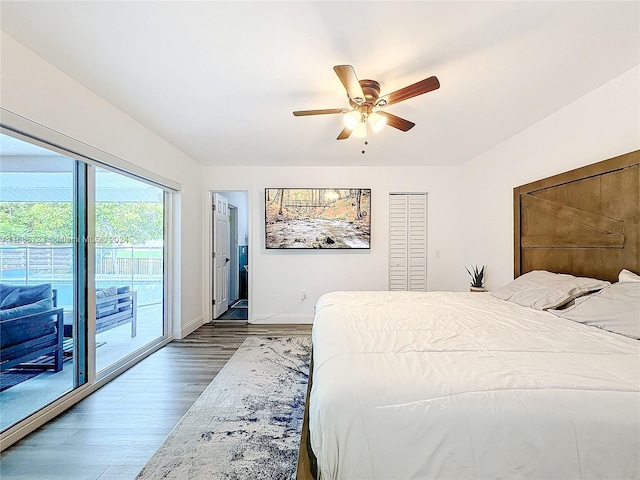 bedroom with access to exterior, dark hardwood / wood-style flooring, ceiling fan, and a closet