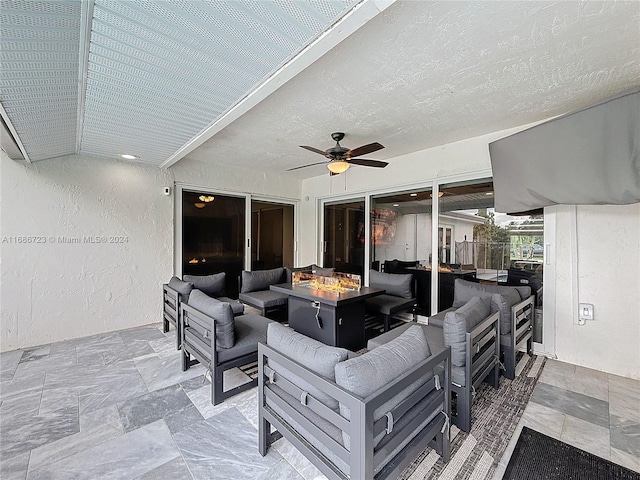 view of patio featuring ceiling fan and an outdoor living space with a fire pit