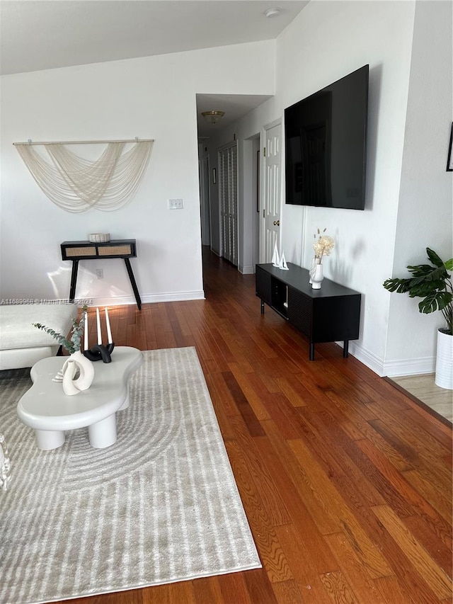 living room featuring wood-type flooring and vaulted ceiling