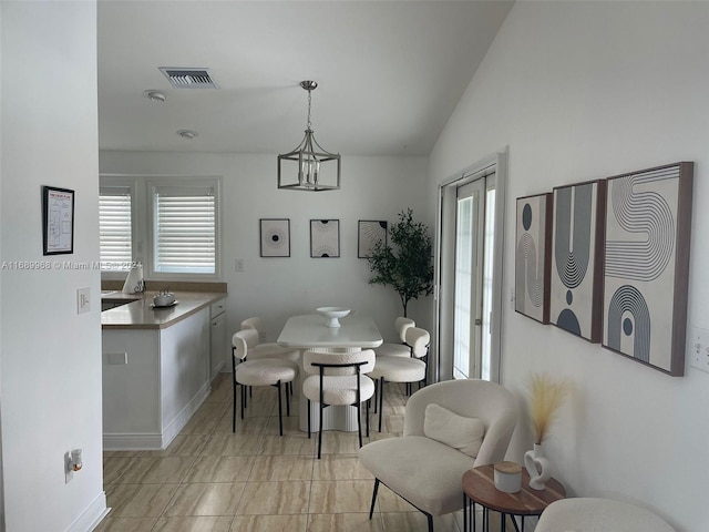 dining space featuring lofted ceiling and an inviting chandelier