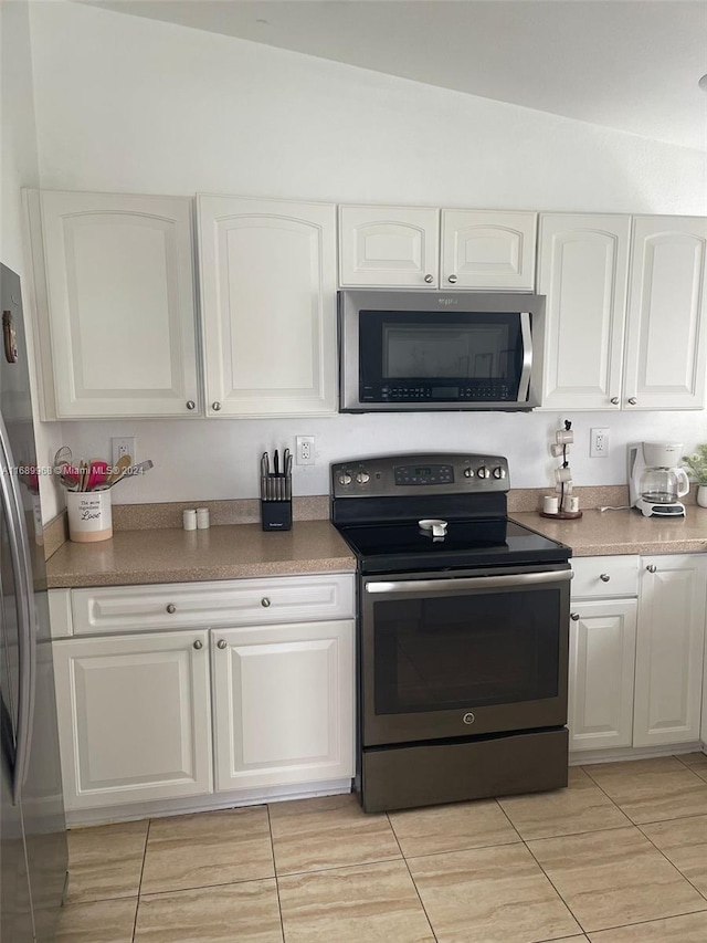 kitchen featuring white cabinetry, appliances with stainless steel finishes, and light tile patterned flooring