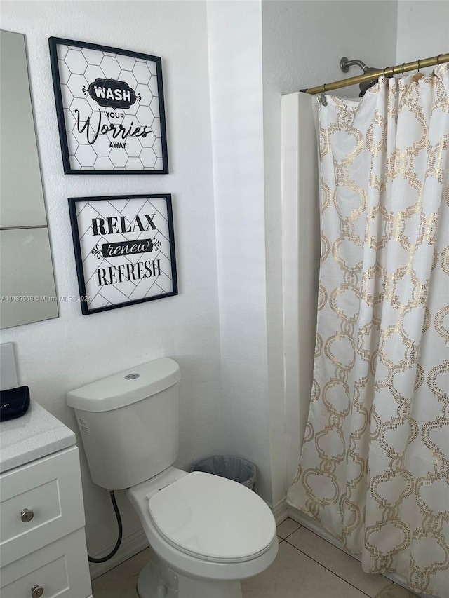 bathroom with toilet, vanity, tile patterned flooring, and curtained shower