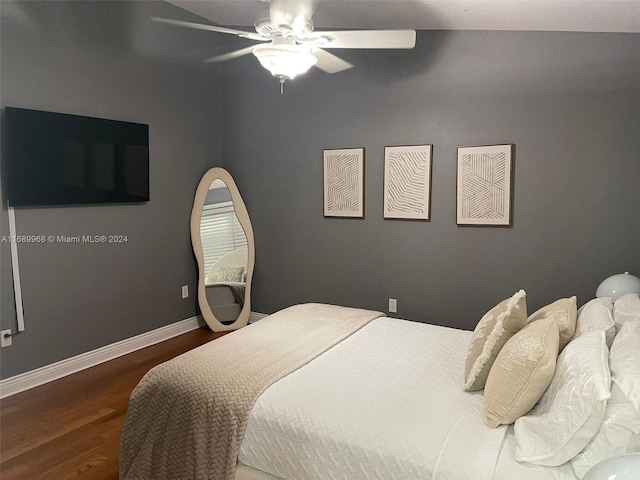 bedroom with dark hardwood / wood-style flooring and ceiling fan