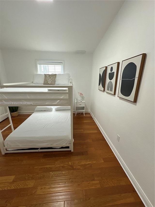 bedroom with dark hardwood / wood-style floors and lofted ceiling