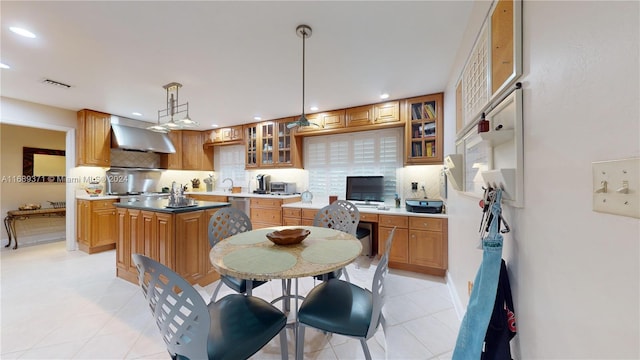 kitchen with a kitchen island, ventilation hood, pendant lighting, and tasteful backsplash