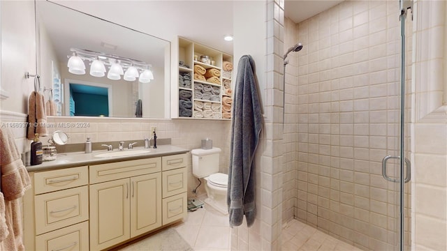 bathroom with tile walls, tile patterned floors, backsplash, vanity, and an enclosed shower