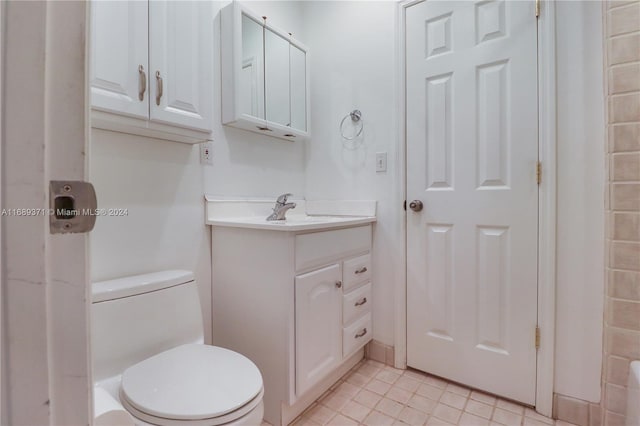 bathroom featuring tile patterned flooring, vanity, and toilet