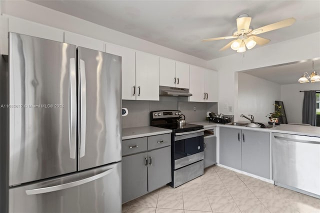 kitchen featuring stainless steel appliances, sink, ceiling fan with notable chandelier, white cabinets, and gray cabinetry