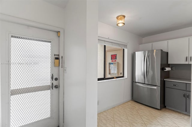 kitchen featuring stainless steel refrigerator, gray cabinetry, a healthy amount of sunlight, and white cabinetry