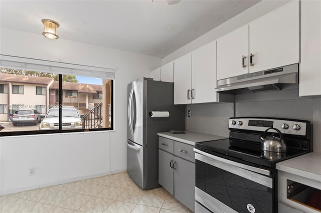 kitchen featuring white cabinets, light tile patterned flooring, and stainless steel appliances