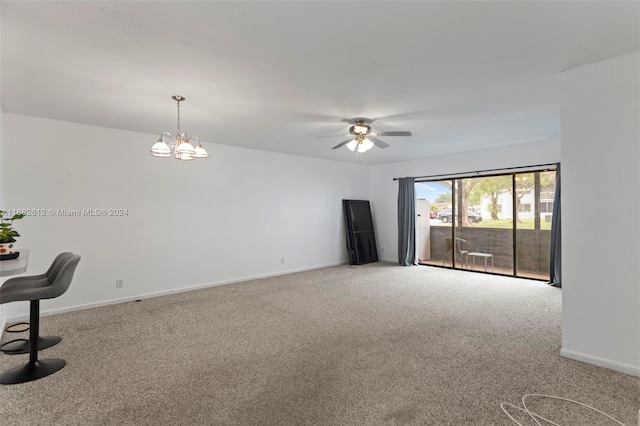 empty room with ceiling fan with notable chandelier and light carpet