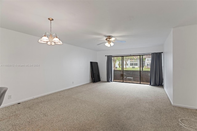 spare room with ceiling fan with notable chandelier and carpet floors