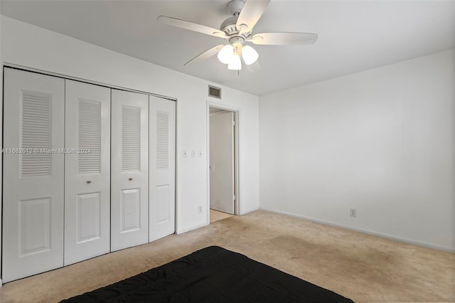 unfurnished bedroom featuring ceiling fan, a closet, and light colored carpet