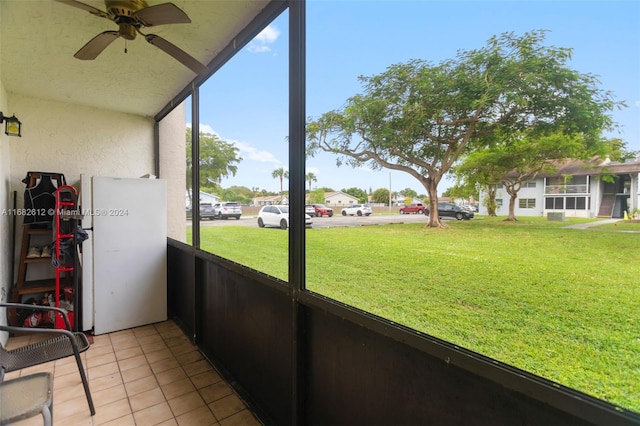 unfurnished sunroom featuring ceiling fan