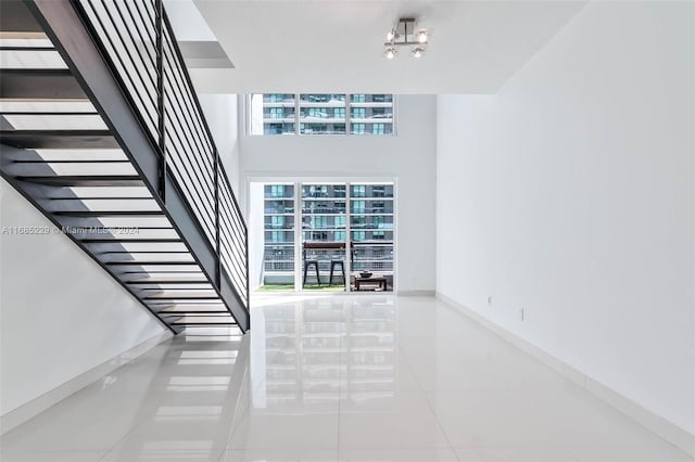 stairs with tile patterned flooring and an inviting chandelier