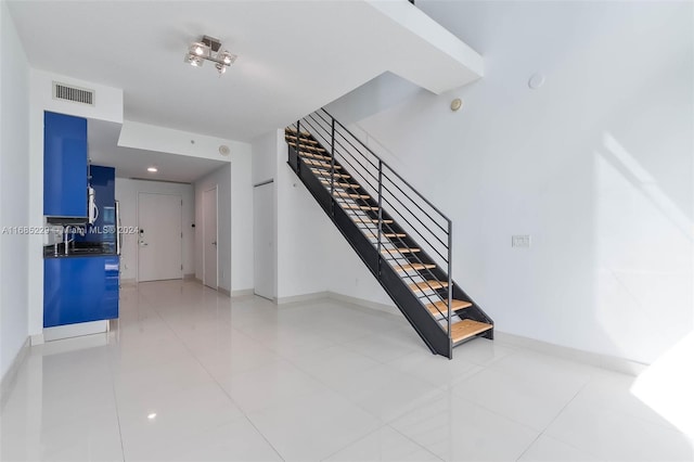 stairway with sink and tile patterned floors