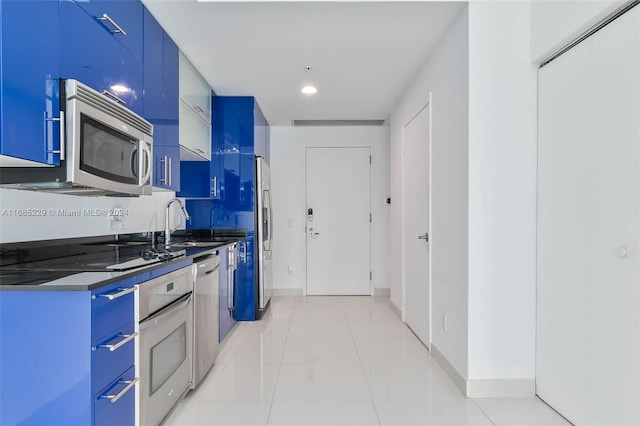 kitchen with blue cabinetry, appliances with stainless steel finishes, and sink