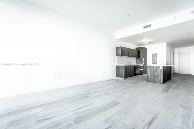 unfurnished living room featuring electric panel and light hardwood / wood-style flooring