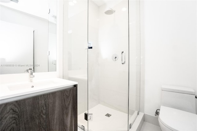 bathroom with vanity, toilet, and an enclosed shower