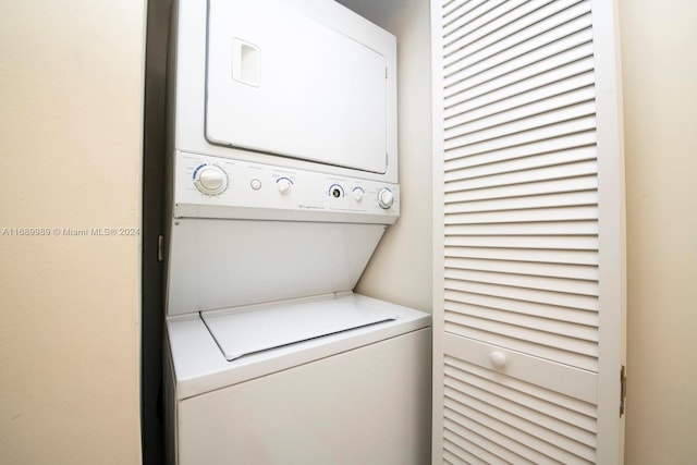 clothes washing area featuring stacked washer and clothes dryer