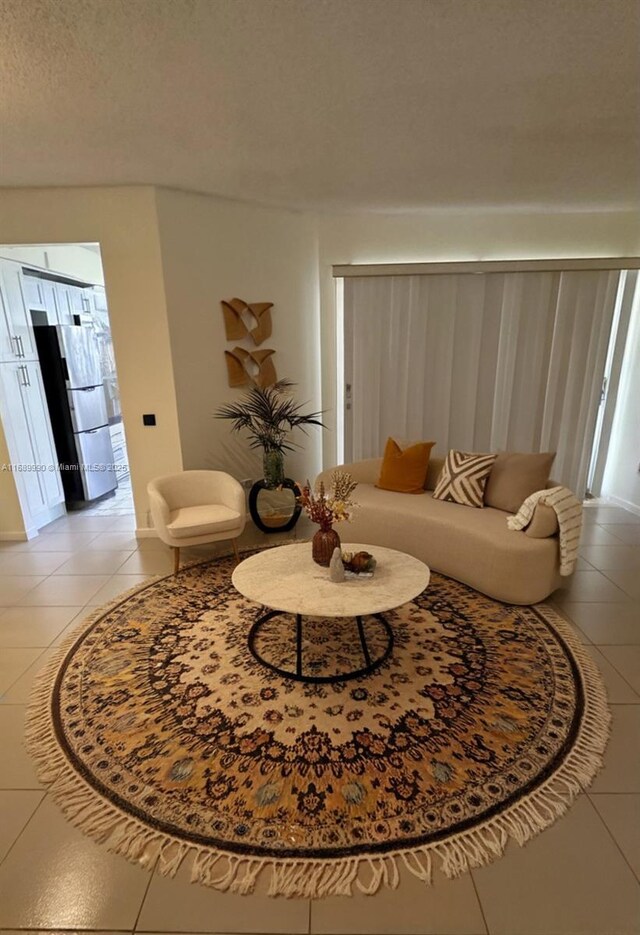 living room with a textured ceiling and light tile patterned floors