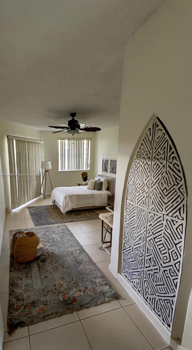 tiled bedroom featuring a textured ceiling and ceiling fan